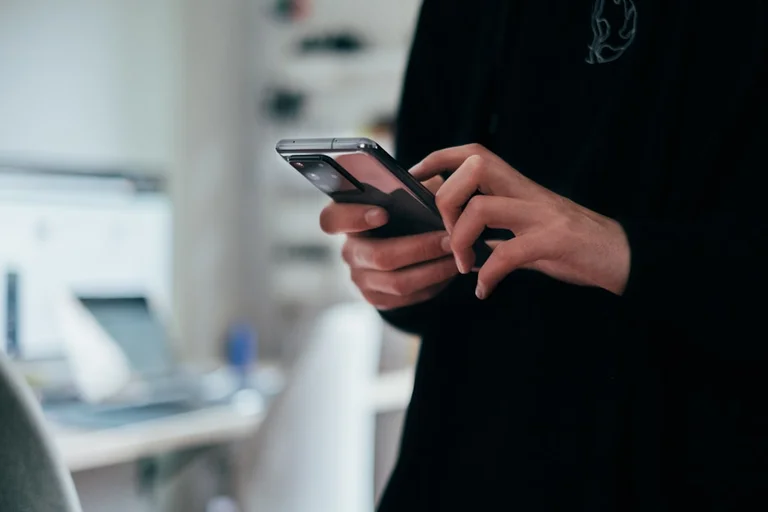 スマートフォンで文字の連絡を送る学生